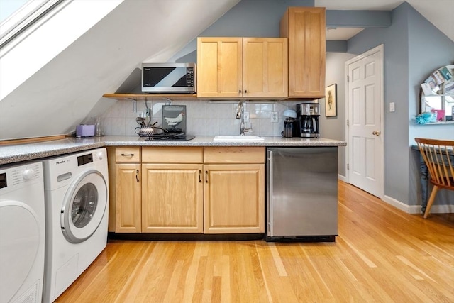 kitchen featuring separate washer and dryer, a sink, light wood-type flooring, fridge, and stainless steel microwave