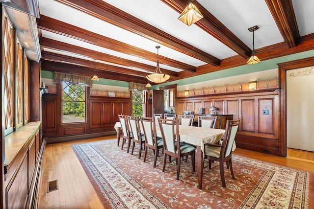 dining room featuring light hardwood / wood-style flooring, ornamental molding, beamed ceiling, and a healthy amount of sunlight