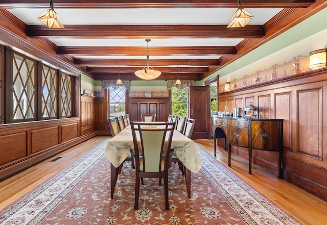 dining space with beamed ceiling and light hardwood / wood-style floors