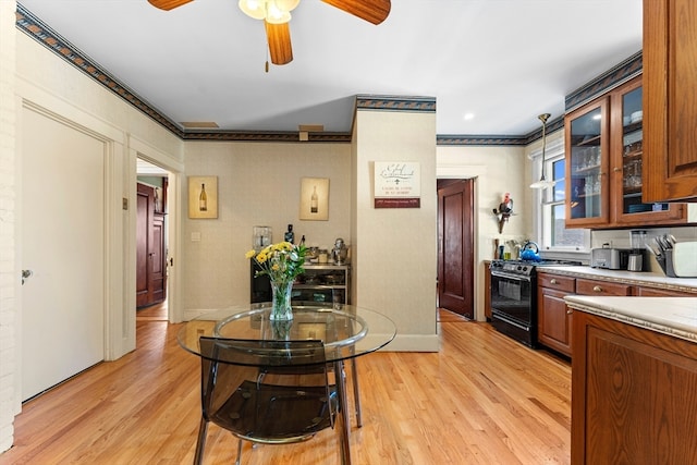 kitchen with ceiling fan, crown molding, light hardwood / wood-style floors, and black range with gas cooktop