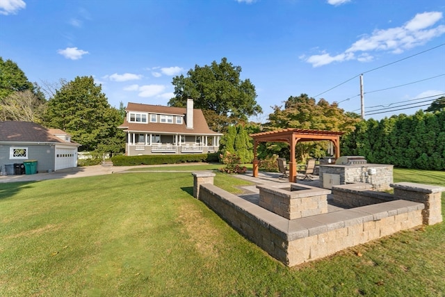 view of yard featuring an outdoor structure, a garage, a pergola, and exterior kitchen