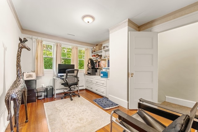 office featuring light hardwood / wood-style flooring, a baseboard heating unit, and crown molding