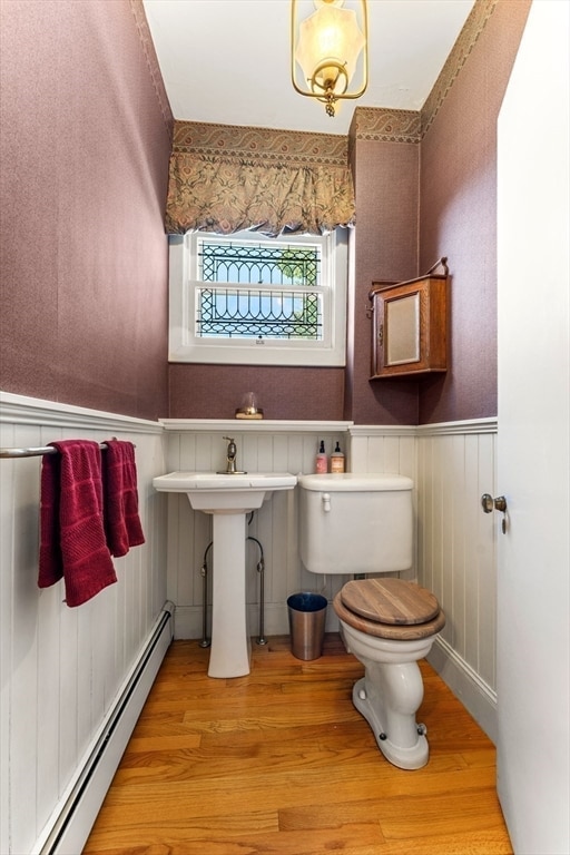 bathroom with wood-type flooring, toilet, and a baseboard radiator