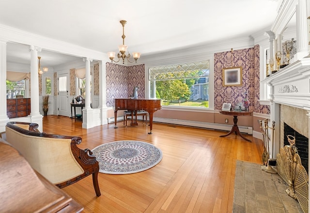 interior space with a notable chandelier, a high end fireplace, decorative columns, and light hardwood / wood-style floors