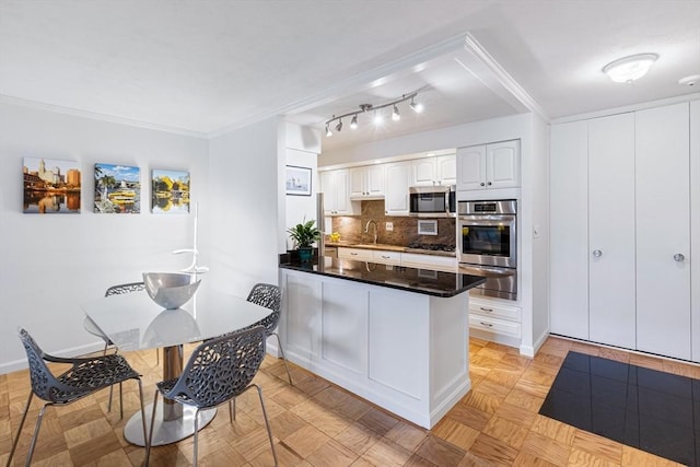 kitchen with tasteful backsplash, dark countertops, a peninsula, stainless steel appliances, and a warming drawer