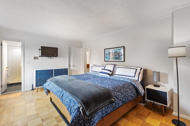 bedroom featuring baseboards, crown molding, and ensuite bathroom