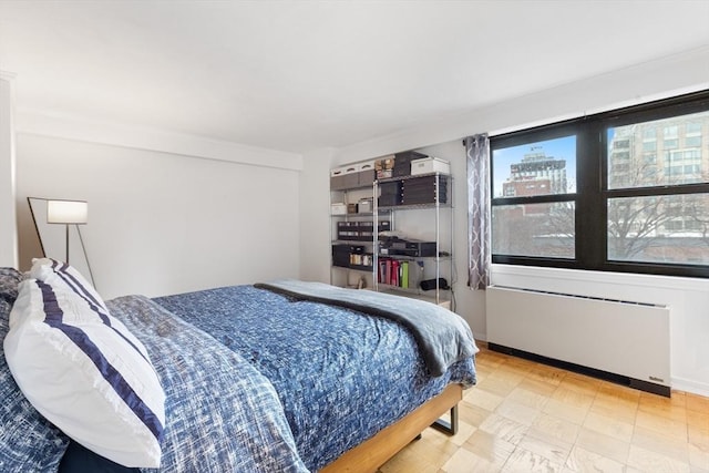 bedroom featuring baseboards, multiple windows, tile patterned floors, and radiator