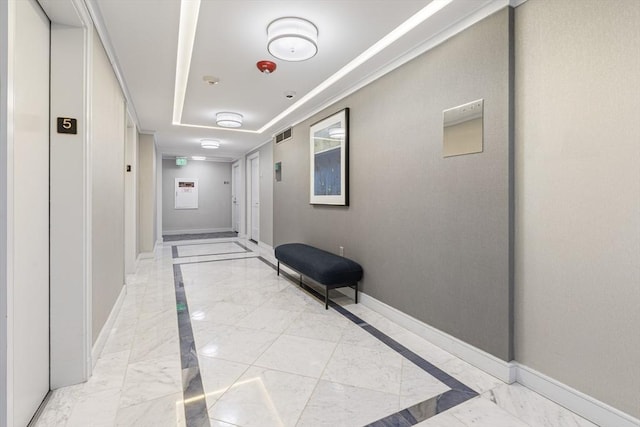 hallway with marble finish floor, visible vents, and baseboards