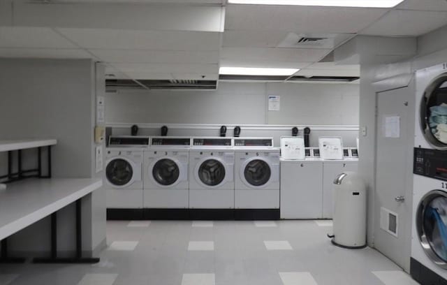 shared laundry area featuring light floors, stacked washer / drying machine, visible vents, and washer and dryer