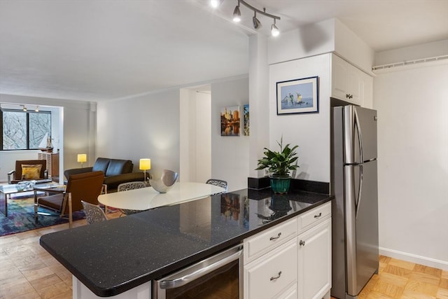 kitchen featuring wine cooler, freestanding refrigerator, open floor plan, white cabinetry, and a peninsula