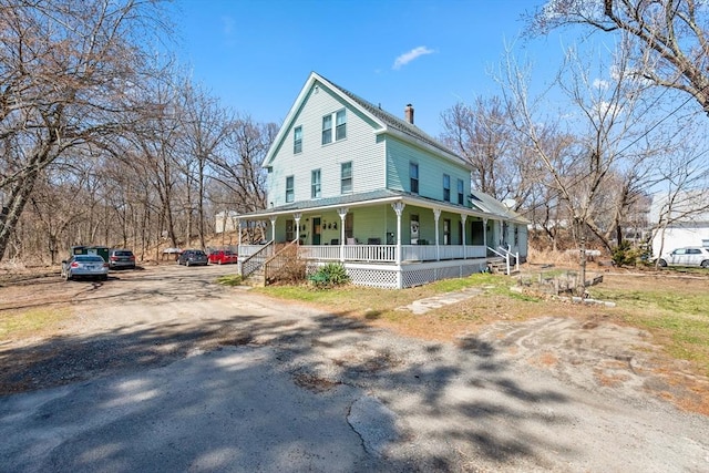farmhouse with a porch and a chimney