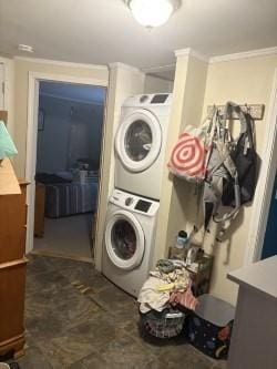 laundry room featuring stacked washer / dryer and ornamental molding
