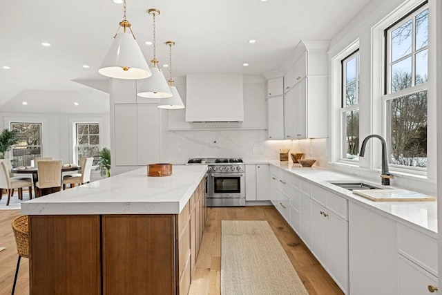 30 Alberta Ave, Newburyport, MA 01950 - kitchen with high end stainless steel range, plenty of natural light, custom range hood, a kitchen island, and recessed lighting