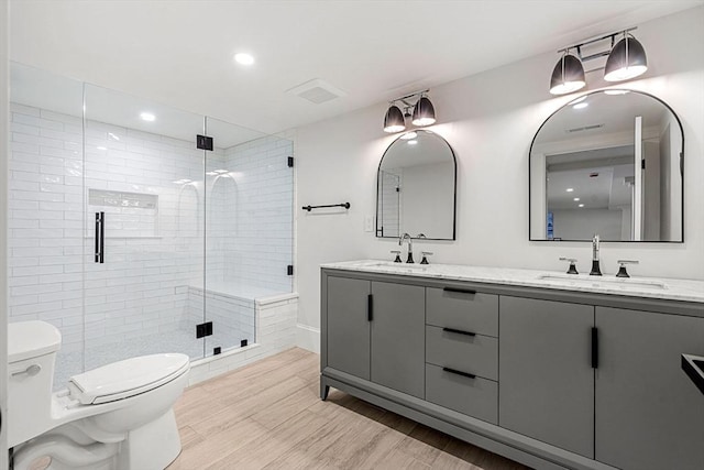 30 Alberta Ave, Newburyport, MA 01950 - full bath featuring toilet, double vanity, a shower stall, recessed lighting, and wood finished floors