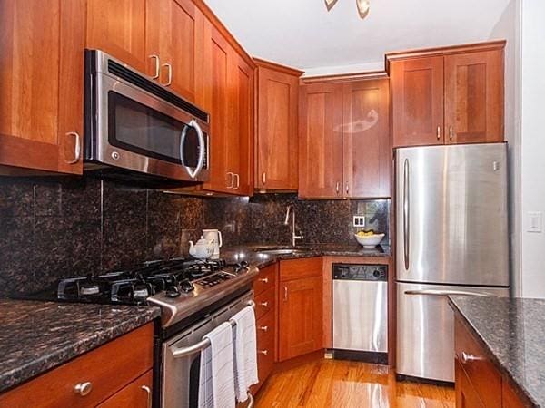 455 Massachusetts Ave Unit 2, Boston, MA 02118 - kitchen with appliances with stainless steel finishes, a sink, brown cabinets, light wood-style floors, and dark stone counters