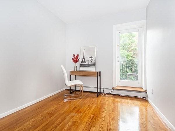 455 Massachusetts Ave Unit 2, Boston, MA 02118 - office space featuring wood finished floors, baseboards, and a baseboard radiator