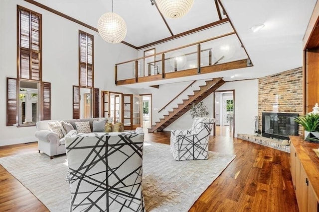 8 Evergreen Ln, Hingham, MA 02043 - living room with wood finished floors, a brick fireplace, baseboards, a towering ceiling, and ornamental molding