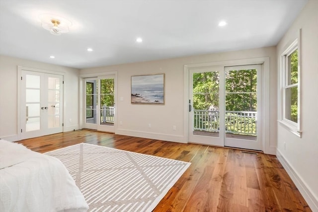 bedroom with light hardwood / wood-style floors, access to exterior, and french doors