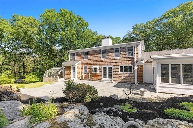 8 Evergreen Ln, Hingham, MA 02043 - rear view of house featuring a chimney, a patio area, and a sunroom
