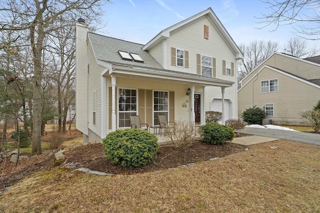 view of front of property featuring covered porch, roof with shingles, driveway, and a chimney