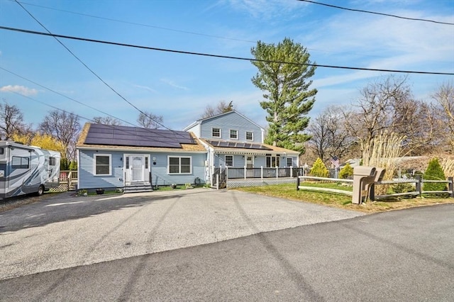 55 Friendship St, Billerica, MA 01821 - view of front of home with roof mounted solar panels, a shingled roof, and a fenced front yard