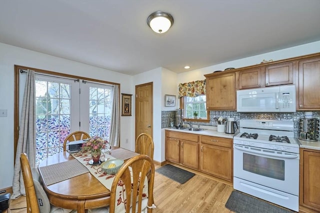 55 Friendship St, Billerica, MA 01821 - kitchen with a sink, white appliances, light wood-type flooring, light countertops, and backsplash