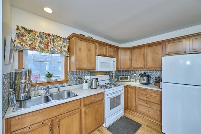 55 Friendship St, Billerica, MA 01821 - kitchen with light countertops, a sink, white appliances, light wood-style flooring, and tasteful backsplash