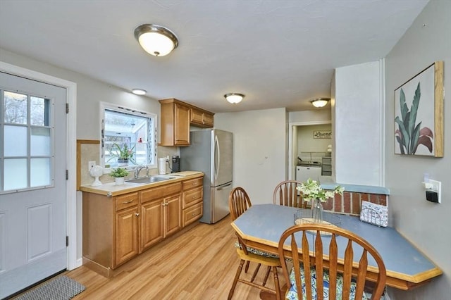 55 Friendship St, Billerica, MA 01821 - kitchen featuring light wood finished floors, a sink, washing machine and dryer, freestanding refrigerator, and light countertops
