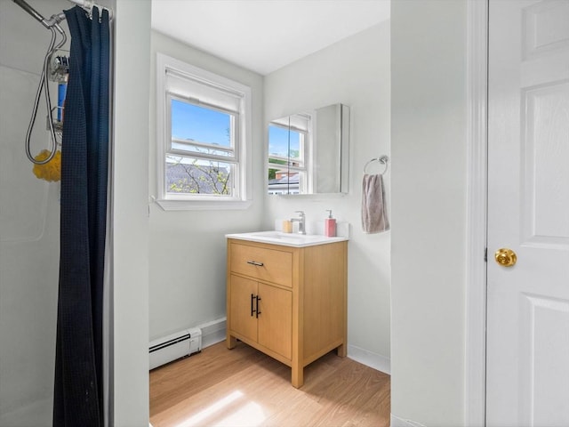 33 Franklin St, Chelsea, MA 02150 - full bath with a baseboard radiator, wood finished floors, baseboards, and vanity