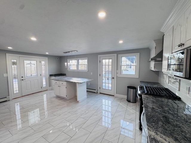 kitchen with a baseboard heating unit, baseboards, marble finish floor, appliances with stainless steel finishes, and a center island