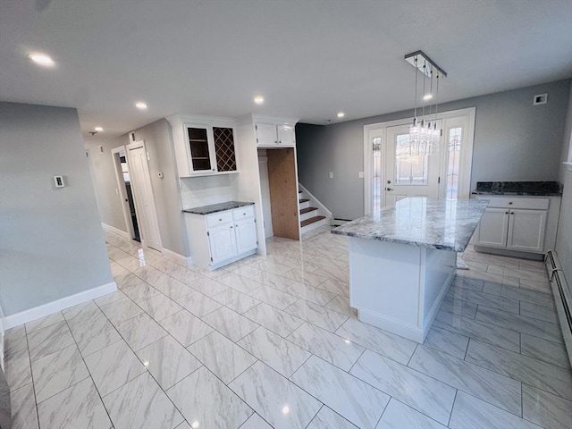 kitchen featuring marble finish floor and white cabinetry