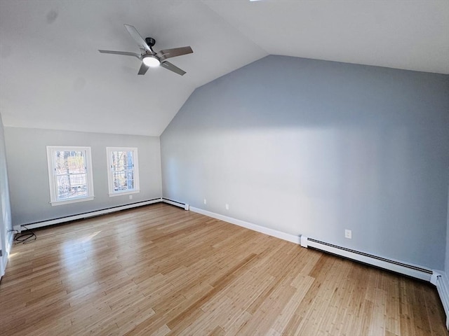 additional living space with a baseboard radiator, baseboard heating, ceiling fan, vaulted ceiling, and wood finished floors