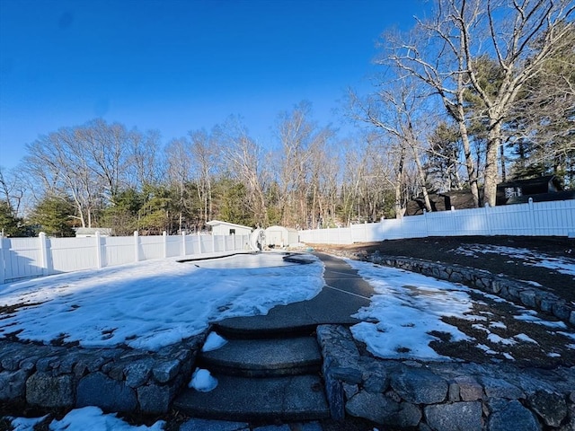 snowy yard with a fenced backyard