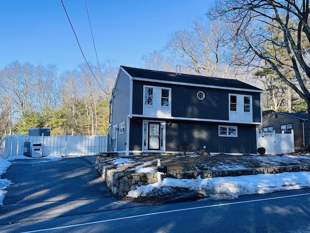 colonial house featuring aphalt driveway and fence