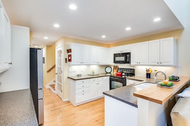 11 Alice Mullens Way Unit 11, Plymouth, MA 02360 - kitchen featuring black appliances, a peninsula, light wood finished floors, a breakfast bar area, and tasteful backsplash