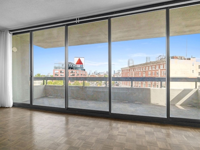 doorway with a wall of windows and parquet flooring