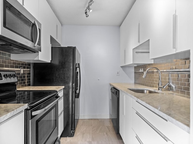 kitchen with decorative backsplash, stainless steel appliances, white cabinets, and sink