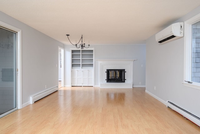 unfurnished living room featuring an inviting chandelier, an AC wall unit, baseboard heating, and light hardwood / wood-style flooring