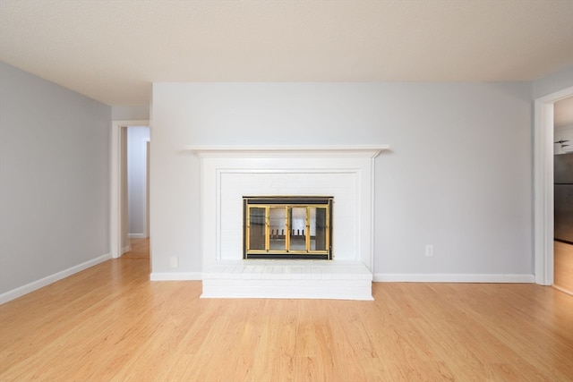 details featuring wood-type flooring, a fireplace, and stainless steel refrigerator