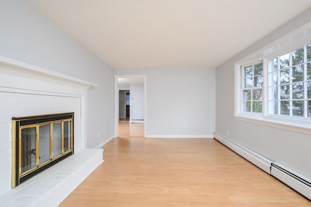 unfurnished living room with a brick fireplace, light wood-type flooring, and a baseboard heating unit