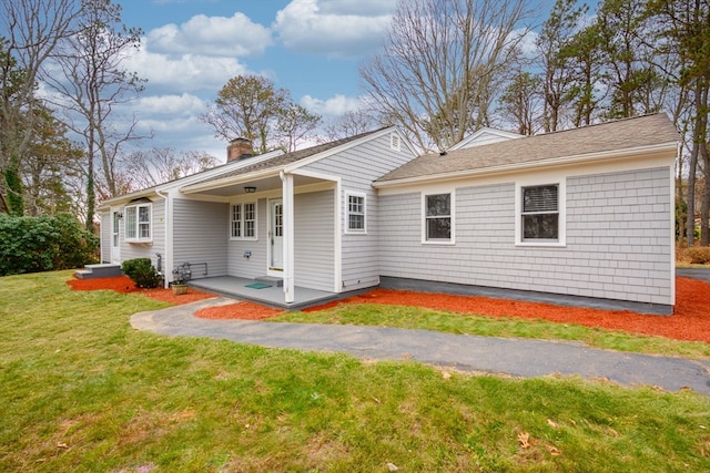 rear view of house featuring a lawn