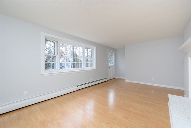 unfurnished living room featuring a baseboard heating unit and light hardwood / wood-style flooring