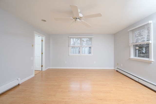 spare room featuring ceiling fan, light wood-type flooring, and a baseboard heating unit