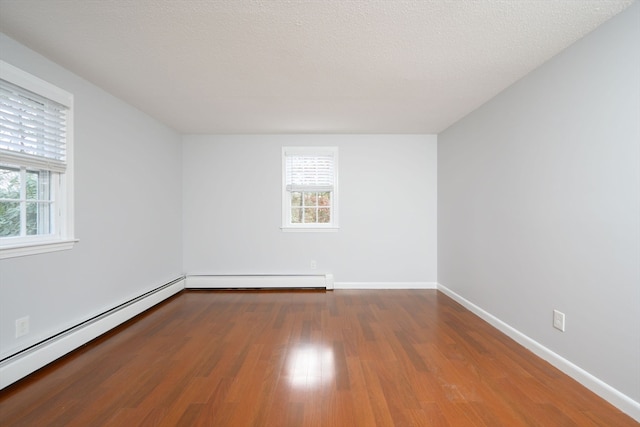 empty room featuring a baseboard radiator, a textured ceiling, and hardwood / wood-style flooring