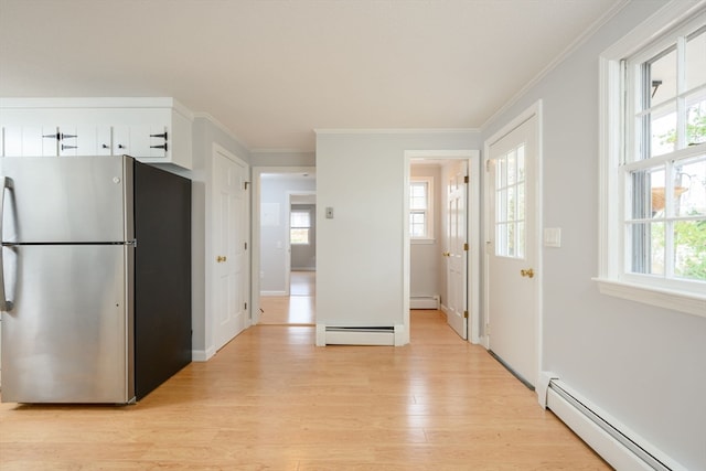 kitchen featuring white cabinets, stainless steel fridge, plenty of natural light, and baseboard heating