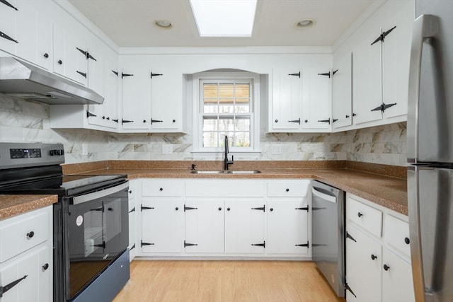 kitchen featuring sink, white cabinetry, stainless steel appliances, and light hardwood / wood-style flooring