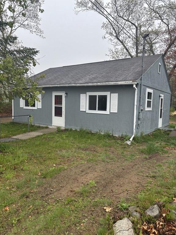 back of house with roof with shingles
