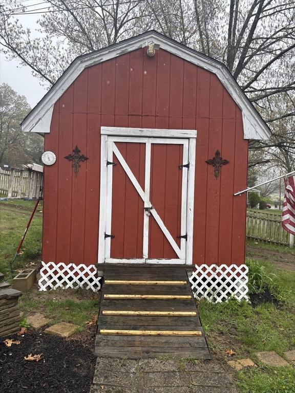 view of shed with fence and entry steps