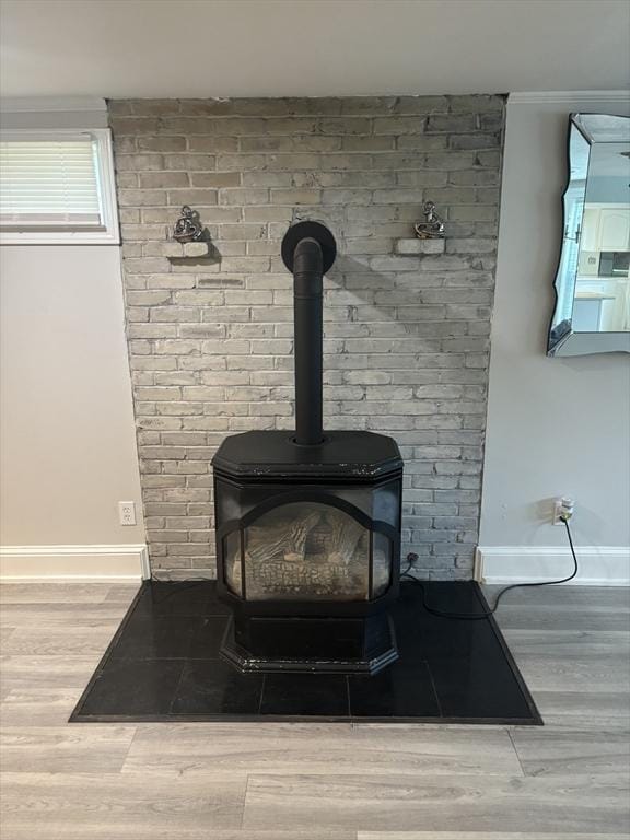 detailed view of wood finished floors, baseboards, and a wood stove