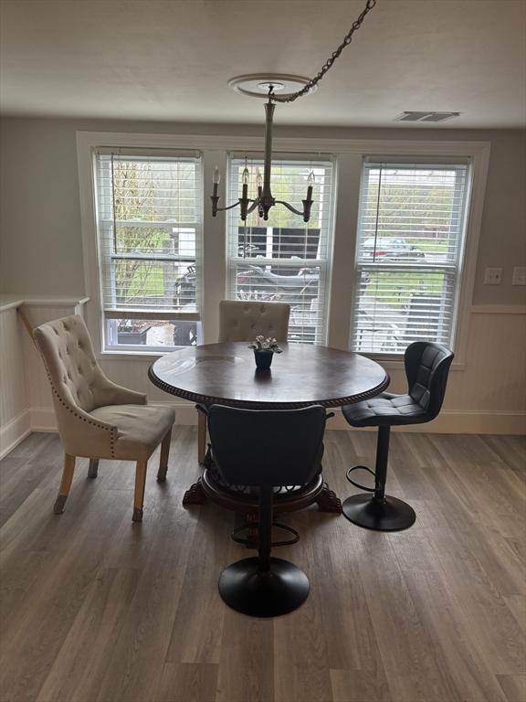 dining area with a chandelier, wood finished floors, and baseboards